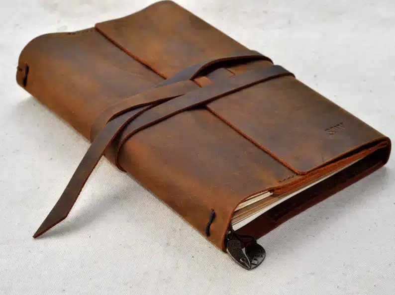 Dark brown leather travel journal shown. 