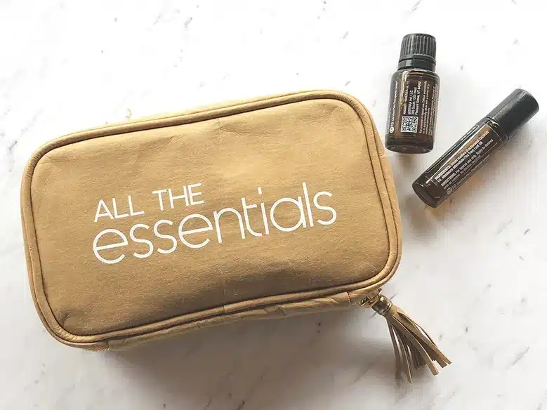 Mother’s Day Gifts for a Daughter: Brown travel bad with white font that says All the essentials and two bottles of essential oils laying beside it. 