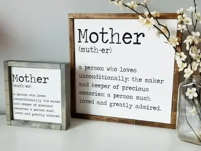 Two signs, one smaller and one larger. Small grey frame one with black font with a poem about mothers and larger brown frame one with a poem about mothers. 