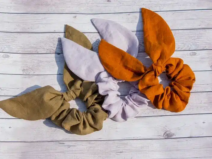 Three bunny scrunchies one army green, one light grey and one rust colored.  