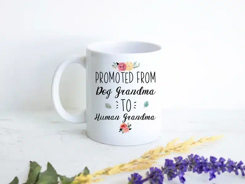 White coffee mug with black font that says Promoted from dog grandma to human grandma. 