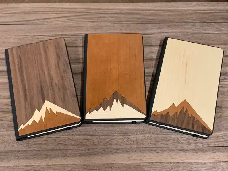 Assorted wooden notebooks with mountains on them