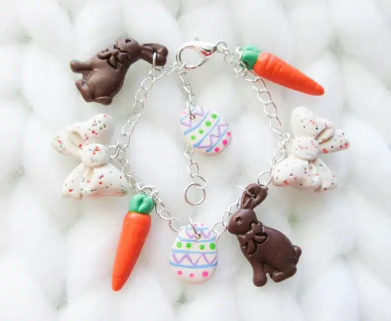 Silver charm bracelet with white poka dot bow charms, two chocolate bunny charms, two carrot charms, and two easter egg charms. 