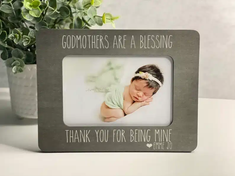 Mother’s Day Gifts for Godmothers: personalized frame with a baby sleeping as the photo, above with white font on the frame it says Godmothers are a blessing, at the bottom of frame it says thank you for being mine. 
