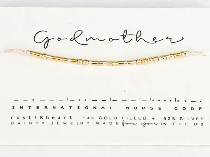 Gold Morse code bracelet that reads godmother. 