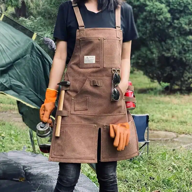 Brown garden or craft apron with various gardening tools show in pockets. 