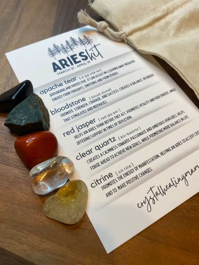 White paper Aries kit checklist showing different crystals and what they do, with the crystals beside the paper. 