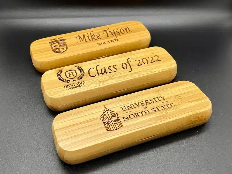 Three wooden pencil cases all engraved. 