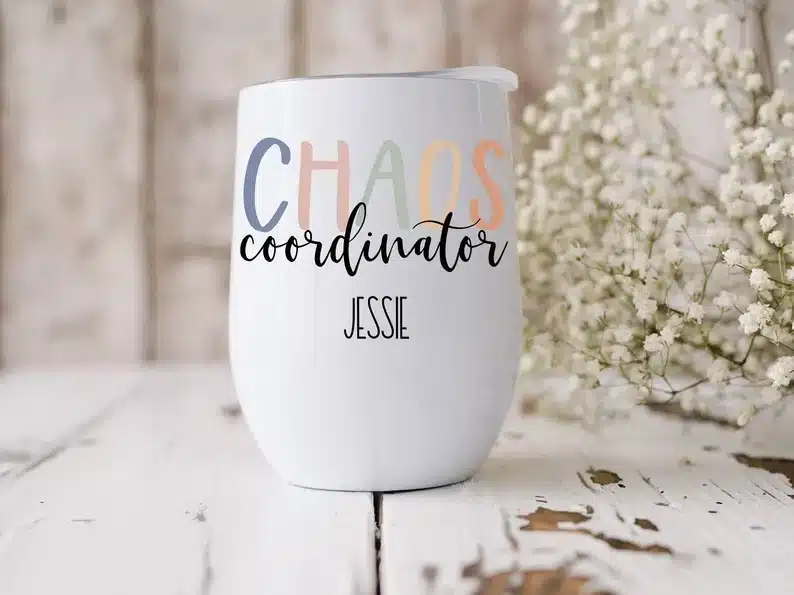 White stemless wine glass with CHAOS coordinator Jessie on it. 