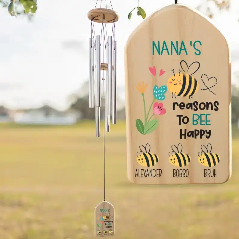 Windchimes with a wooden piece at the bottom that says Nana's reasons to BEE happy and a nan bee and three little bees below. with names below. 