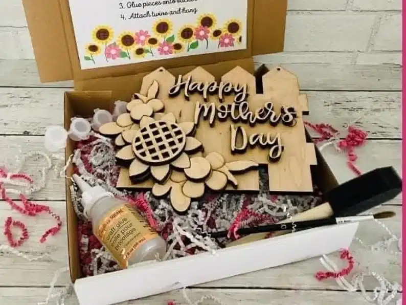 Opened box showing supplies to make a mother's day wooden sign. 