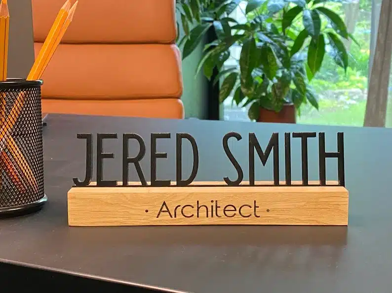 Wooden based name plate with big black letters on top with the name Jered Smith. 