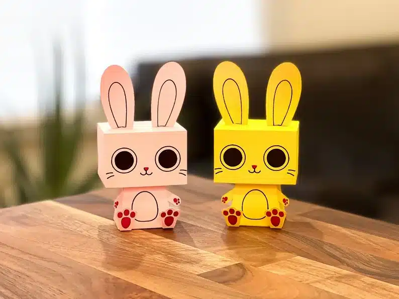 Printable Easter bunny made of paper, one light pink and one yellow. 