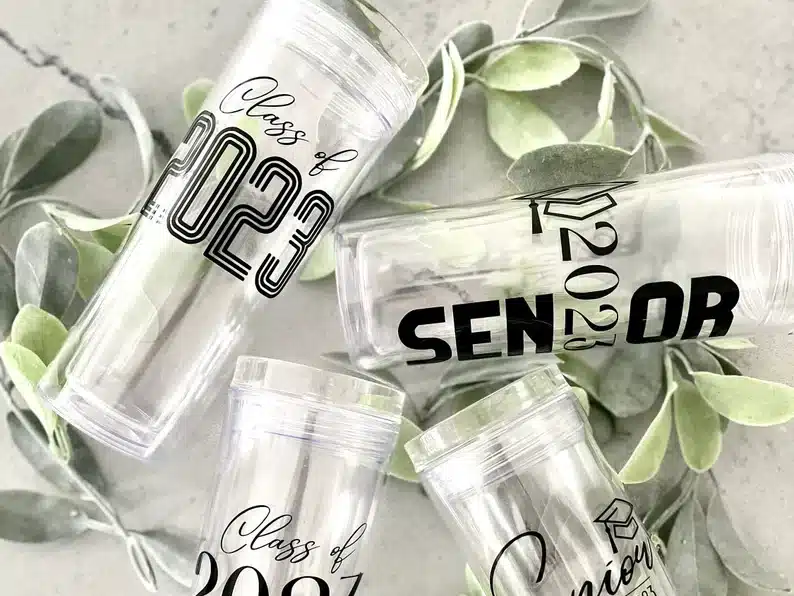 tall clear tumbler glasses with black font that says senior, class of 2023. 