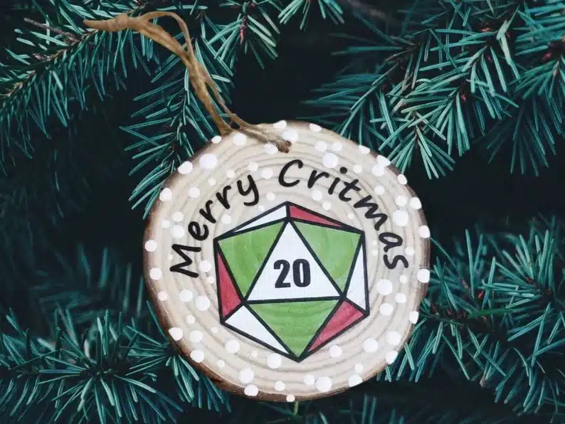 Wooden Christmas ornament that says Merry Christmas with a D&D dice on it. 