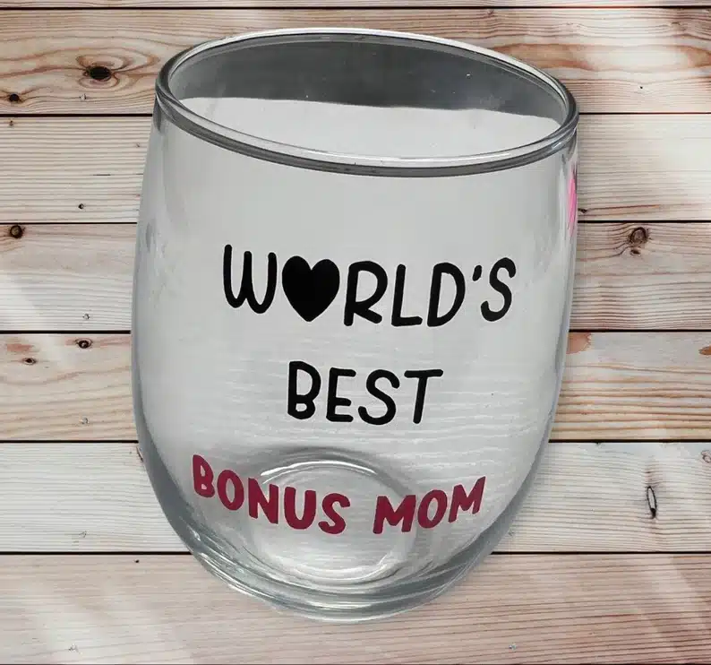 Mother’s Day Gifts for Step Moms: Clear stemless wine glass with black font that says world's best bonus mom, bonus mom in red font. 