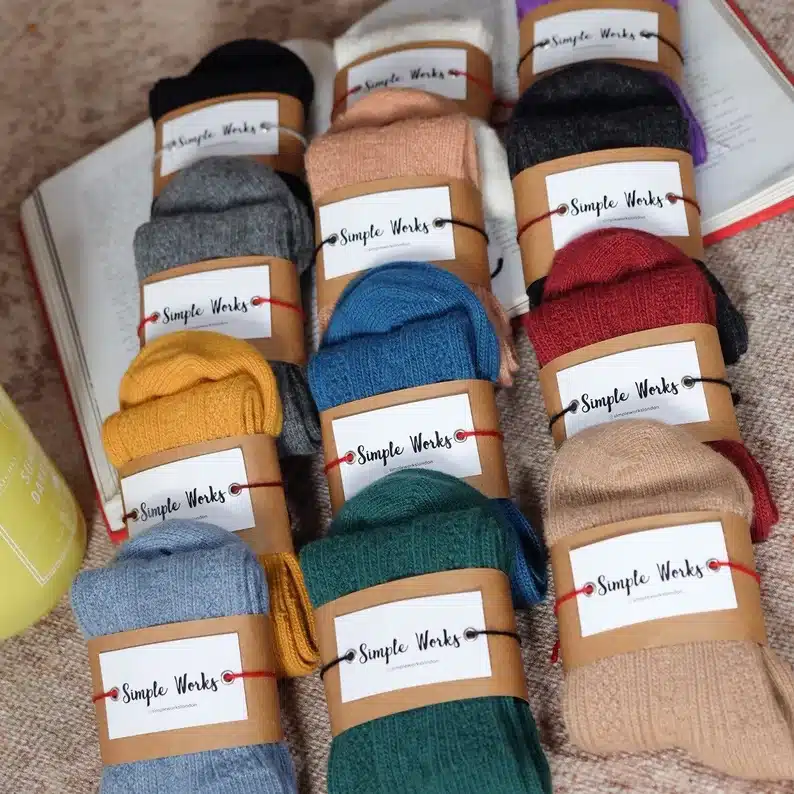 Various wool knitted socks each different colored with labels on them. 