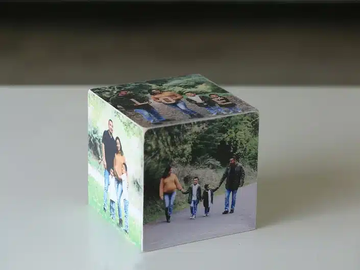 Square personalized photo cube with various photos of a family of four shown. 