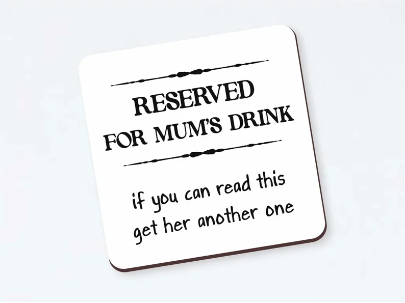 White coasters with black writting that says RESERVED FOR MUM'S DRINK if you can read this get her another one. 