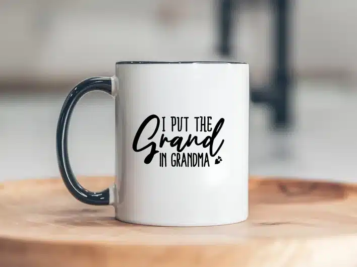 White coffee mug with black handle with black font that says I put the grand in grandma. 