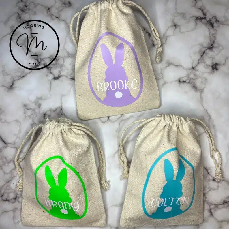 Three personalized bags each with a bunny and a name on it. 