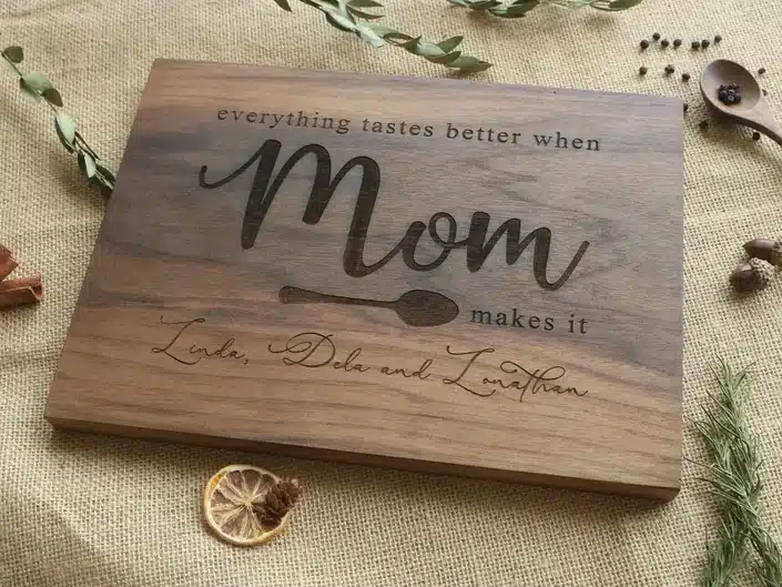Wooden personalized cutting board engraved that says Everything tastes better when MOM makes it. 
