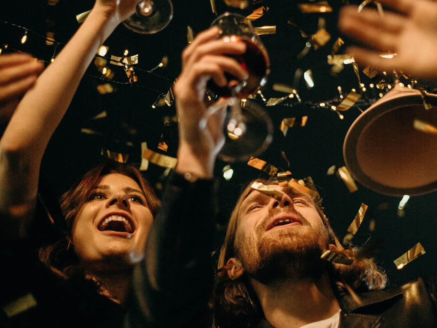 Two people raising their glasses and celebrating together