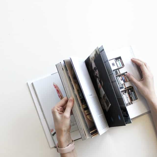 Showing hands flipping through a photo book. 