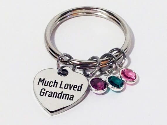 Silver keychain with a heart shaped charm that says Much loved grandma, with three charms each a different birthstone color.