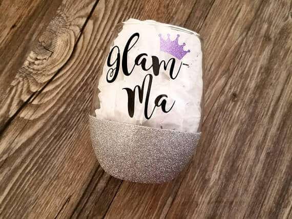 Clear stemless wine glass, half covered in silver sparklers the other with black font that says Glam-ma