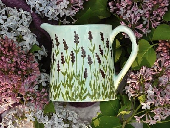 White milk jug with painted lavender all over it. 