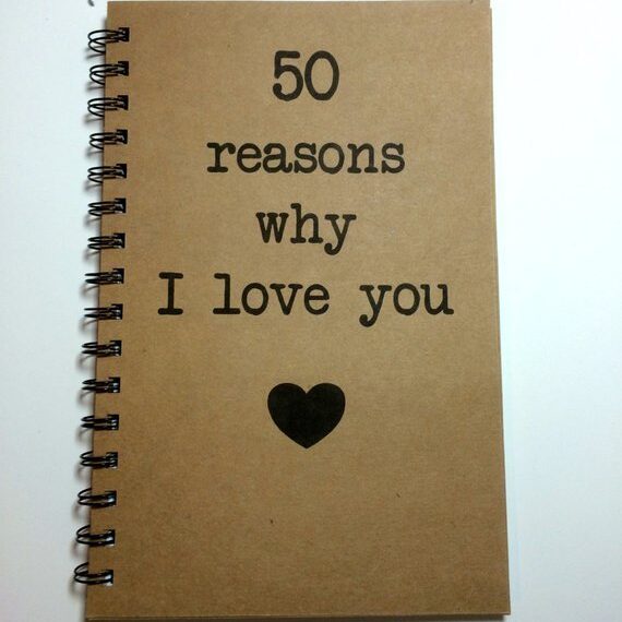Brown journal with black spiral coil with black font that says 50 reasons why I love you with a black heart below. 