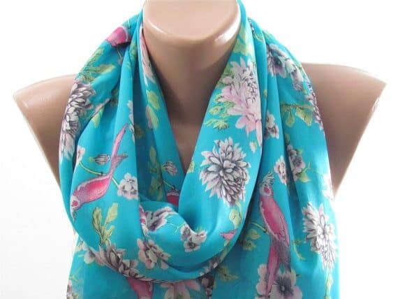 Mother's day gifts for sister-in-laws include this beautiful scarf. Light blue scarf with flowers and tropical pink birds on it. 