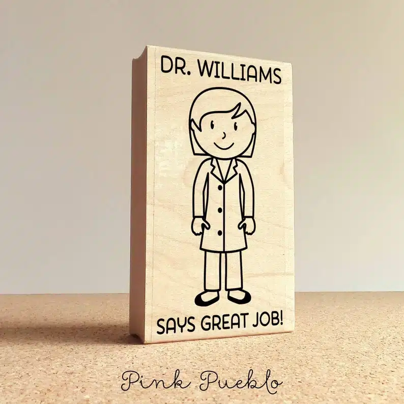 Gift Ideas for a Professor: wooden stamp with a drawing of a woman that says Dr. Williams says great job! 