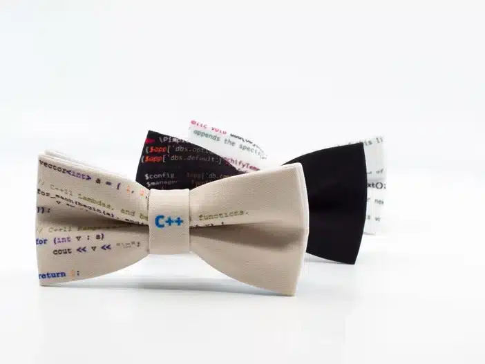 Three geeky bow ties, tan, black, and white. 