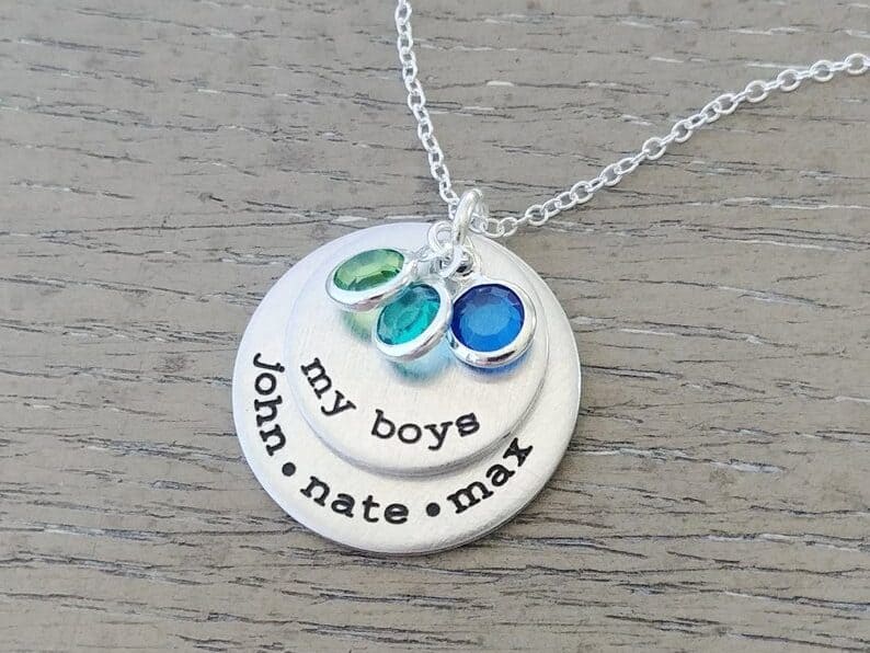 Silver necklace with three birthstone charms, a circle charm that says My boys and a larger circle charm that says John. Nate. Max.