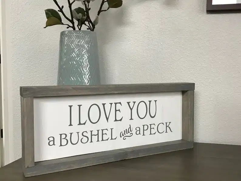 Wooden framed art that says I love you a bushel and a peck. 