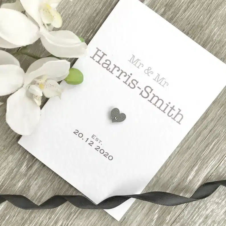 Beautiful Cards for a Gay Wedding: White card with grey font that says "Mr. & Mr. Harris-Smith" with a grey heart and "est 20.12.2020. 
