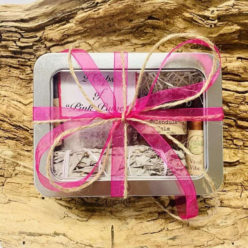 Mother's Day Gifts for Cancer Patients - Silver box with a clear top filled of various items wrapped with a pink bow.