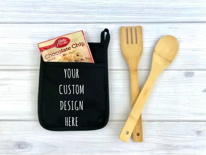 Mother’s Day Gifts for Neighbors: Black pot holder with a ouch that has a chocolate chip mix in it, white font on it that says 
