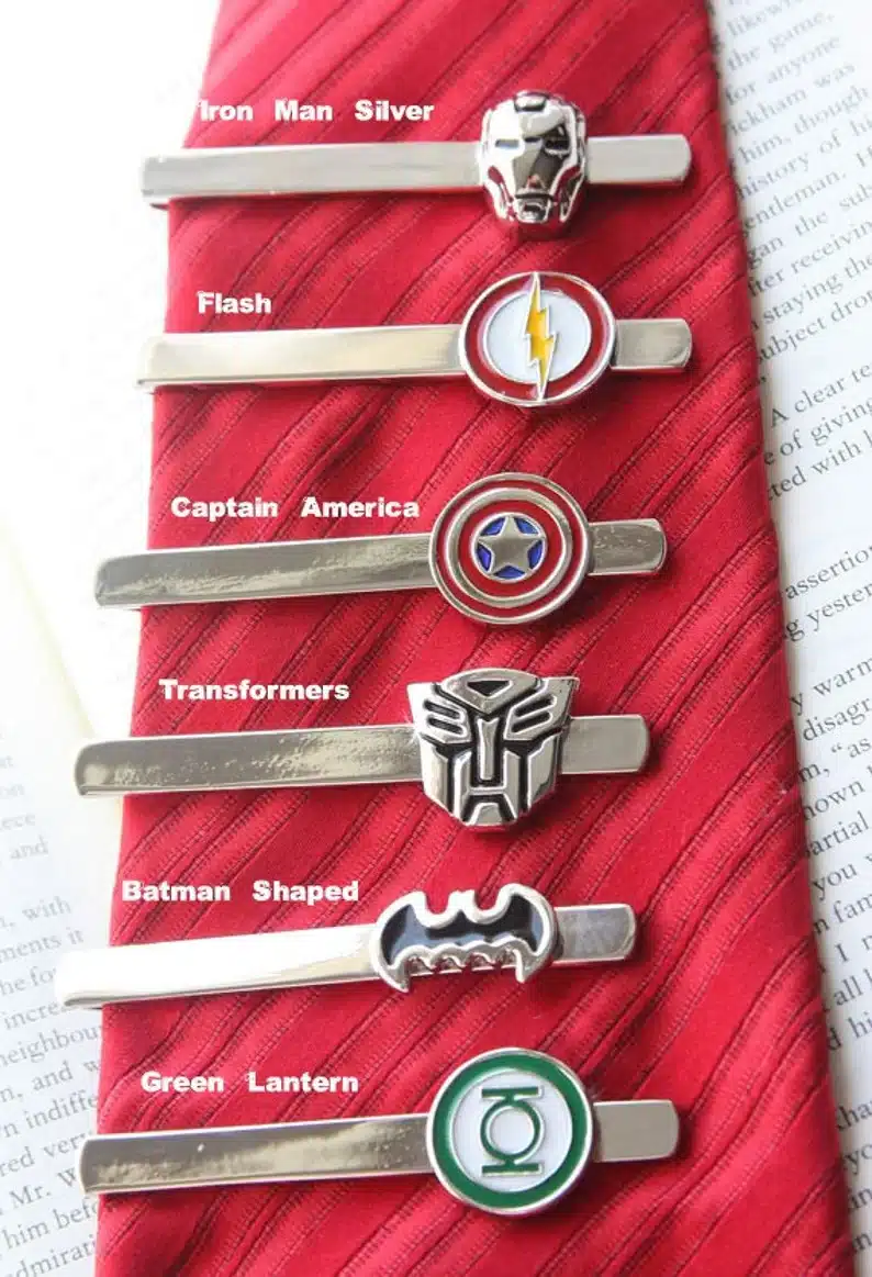 Red tie with various super hero tie clips on it. 