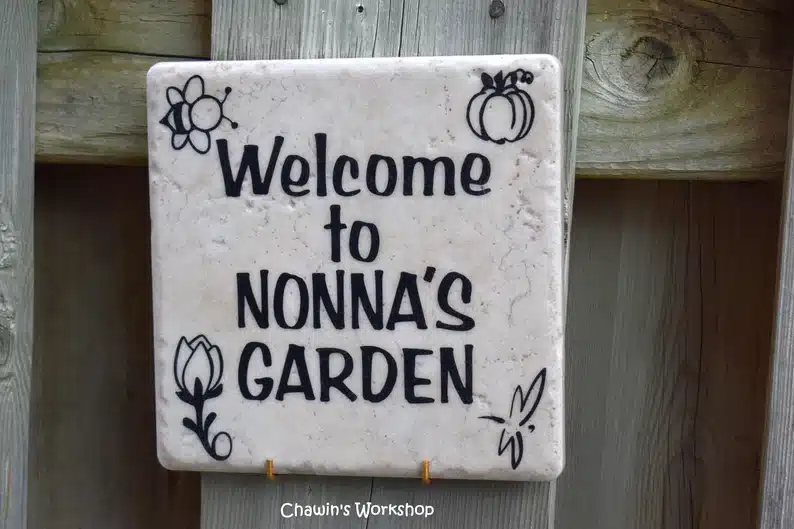 Square sign with black font that says Welcome to Nonna's Garden. 
