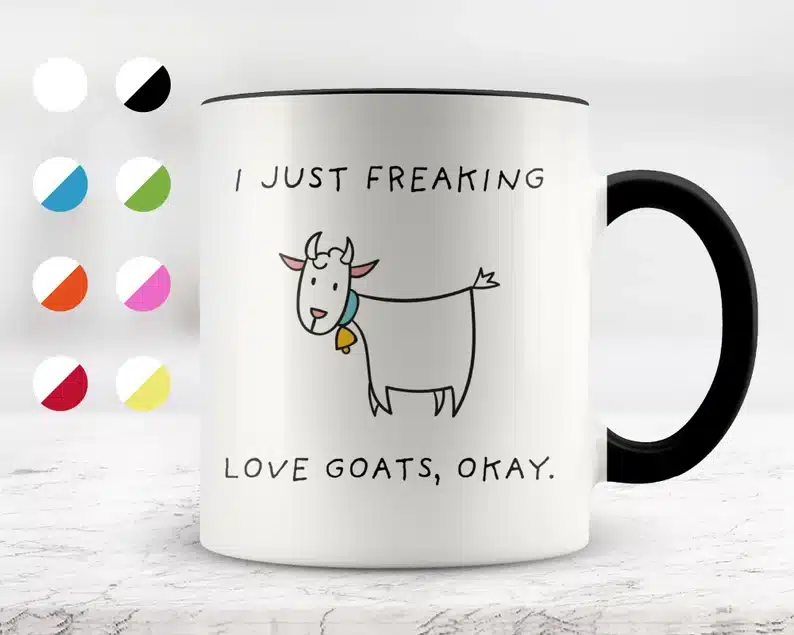 White coffee mug with a black hand with black font that says I just freakin love goats, okay. with a cartoon goat on it. 