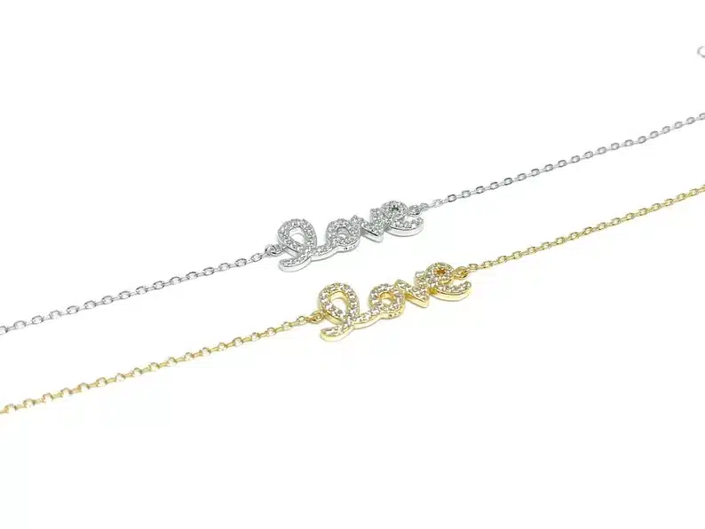 Two bracelets shown, one silver with LOVE and one gold with LOVE. 