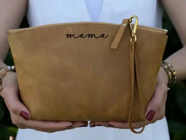 Brown purse that says mama in black font. 