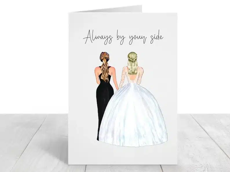 White card with the backs of a woman wearing a black dress and the other wearing a white wedding dress that says Always by your side in black font above. 