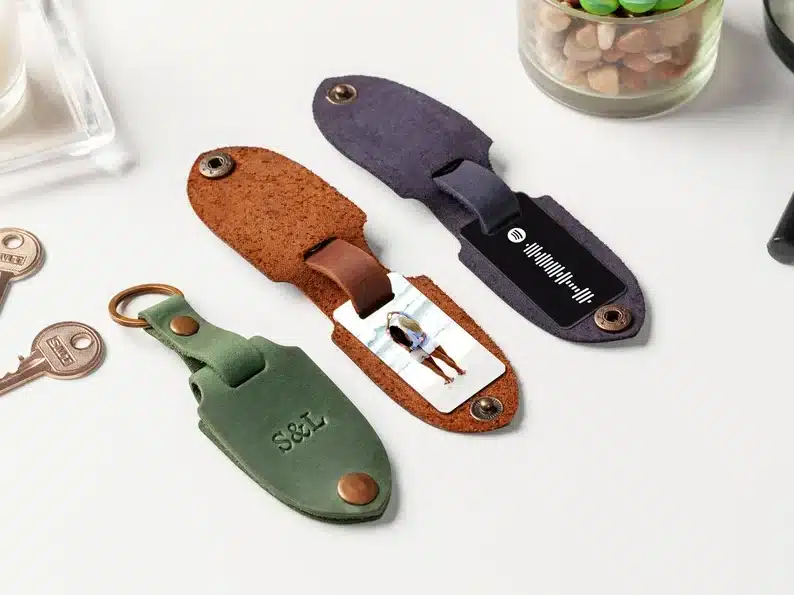 Three leather keychainrs, one green, brown, and navy. 