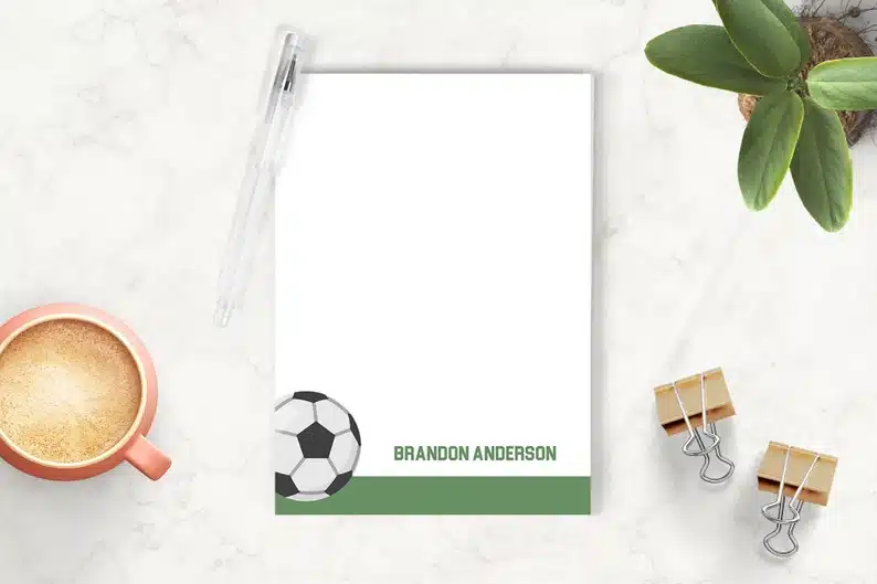 White notepad with a soccer ball and name on the bottom. 