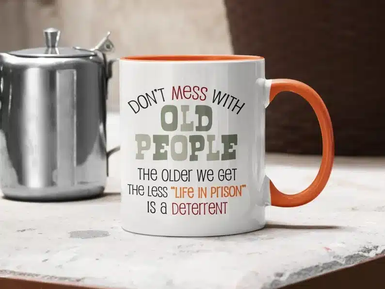 Mother's Day Gifts for Nursing Home Residents - White coffee mug with orange handle and inside with front that says "don't mess with old people the older we get the less "life in prison" is a deterrent" 