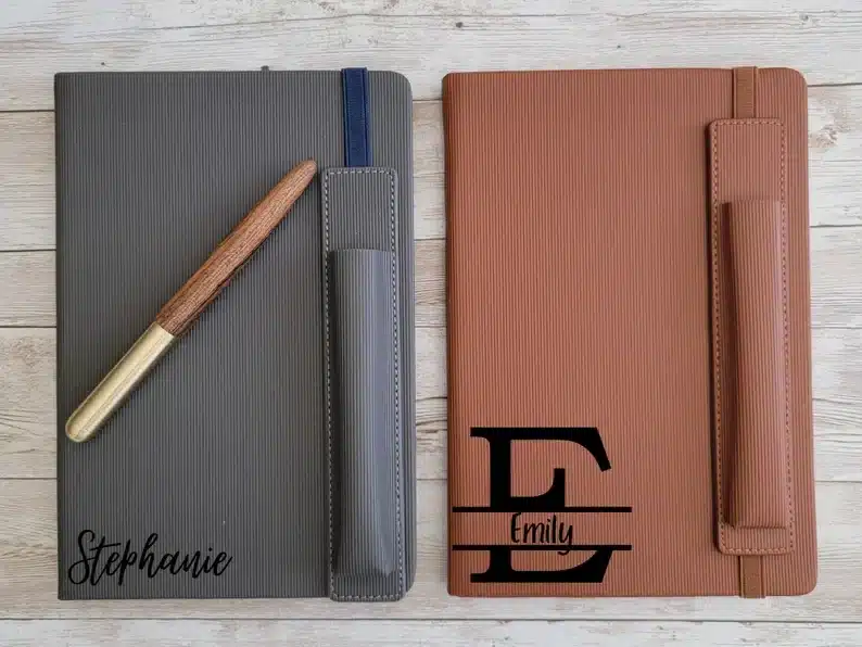 Two monogrammed journals, one light grey and light brown. 